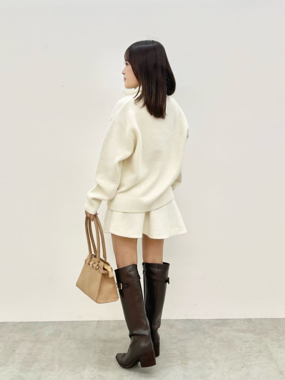 ホワイト系のワンピース、ブラウン系のブーツを着用したレディースの秋コーディネートの3枚目の写真