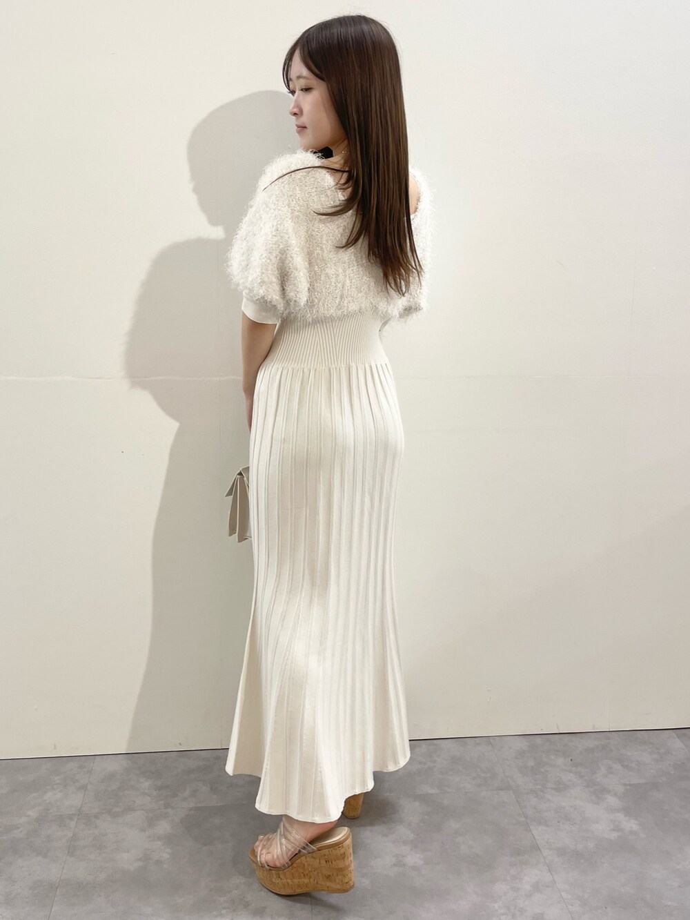 ホワイト系のワンピース、ベージュ系のショルダーバッグ、その他のサンダルを着用したレディースの春コーディネートの7枚目の写真