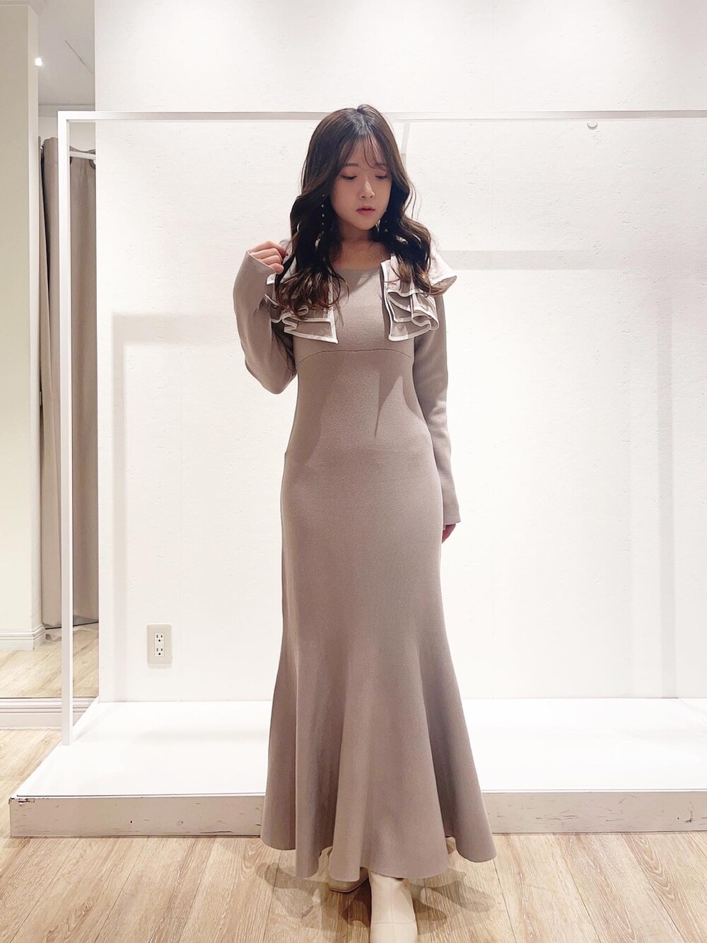 ベージュ系のワンピース、ホワイト系のその他アウター、ホワイト系のブーツを着用したレディースの秋コーディネートの3枚目の写真