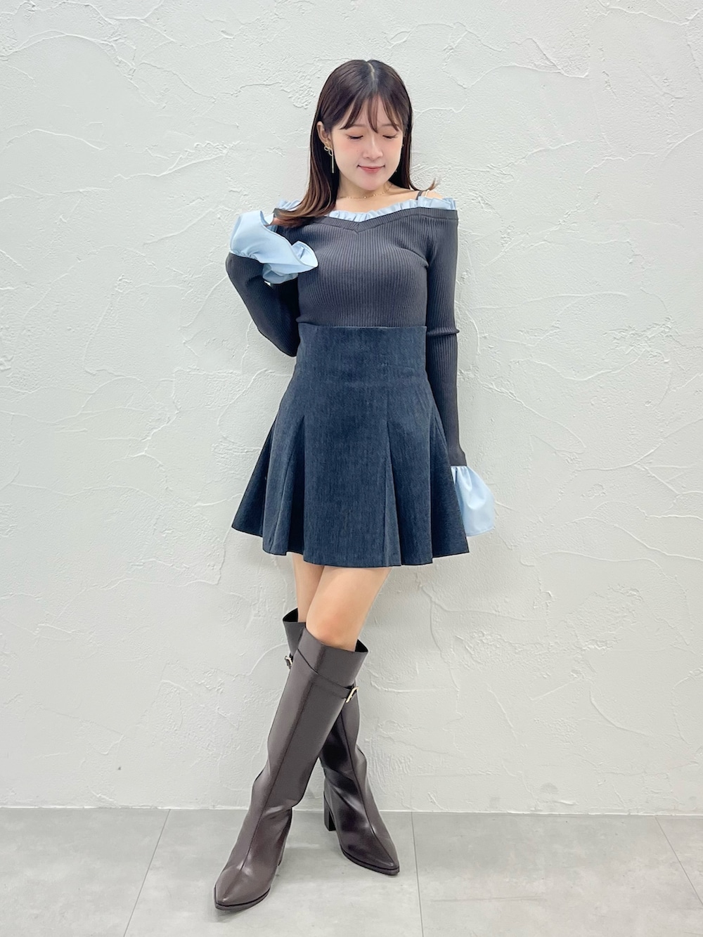 グレー系のニット/セーター、グレー系のテーラードジャケット、グレー系のスカートを着用したレディースの秋コーディネートの3枚目の写真