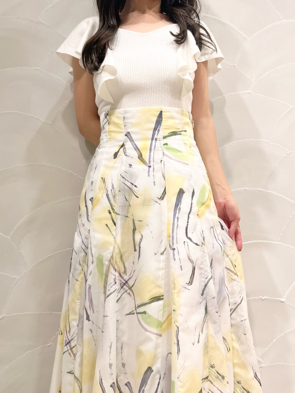 ホワイト系のニット/セーター、イエロー系のスカートを着用したレディースの夏コーディネートの4枚目の写真