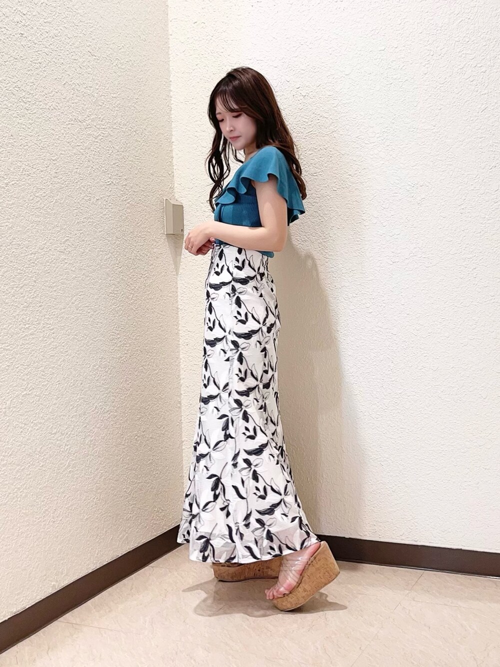 ホワイト系のスカート、グリーン系のニット/セーター、その他のサンダルを着用したレディースの春コーディネートの2枚目の写真