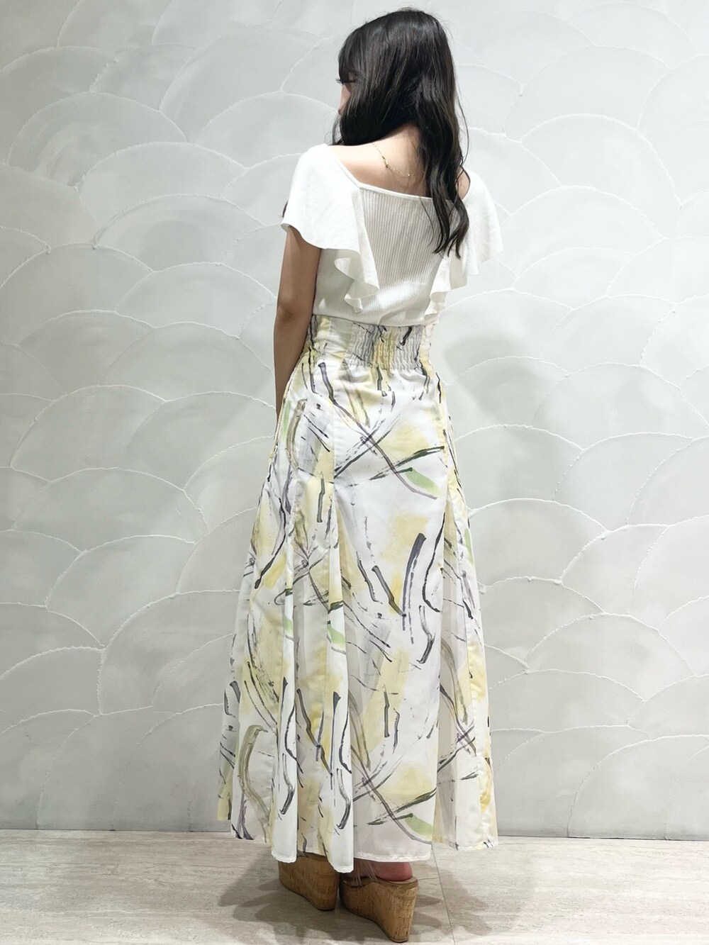 ホワイト系のニット/セーター、イエロー系のスカートを着用したレディースの夏コーディネートの3枚目の写真