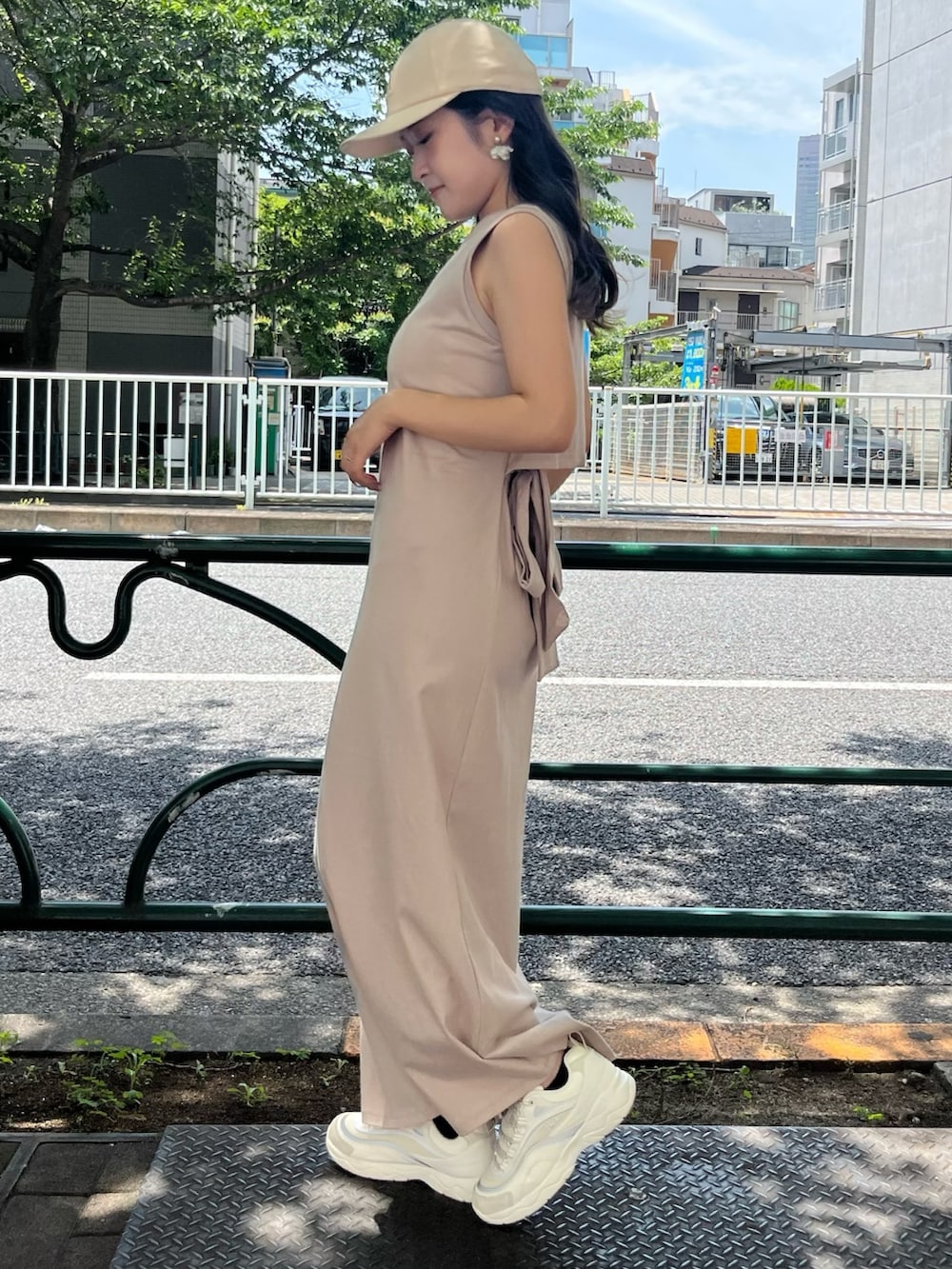 ベージュ系のスニーカー、ベージュ系のワンピース、ベージュ系のキャップを着用したレディースの夏コーディネートの4枚目の写真