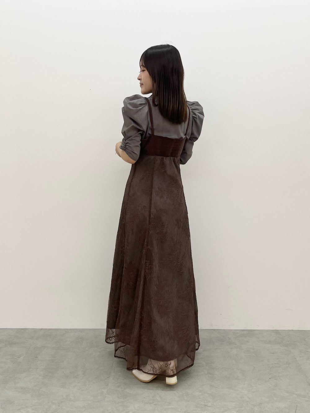 ブラウン系のワンピース、ホワイト系のブーツを着用したレディースの夏コーディネートの3枚目の写真