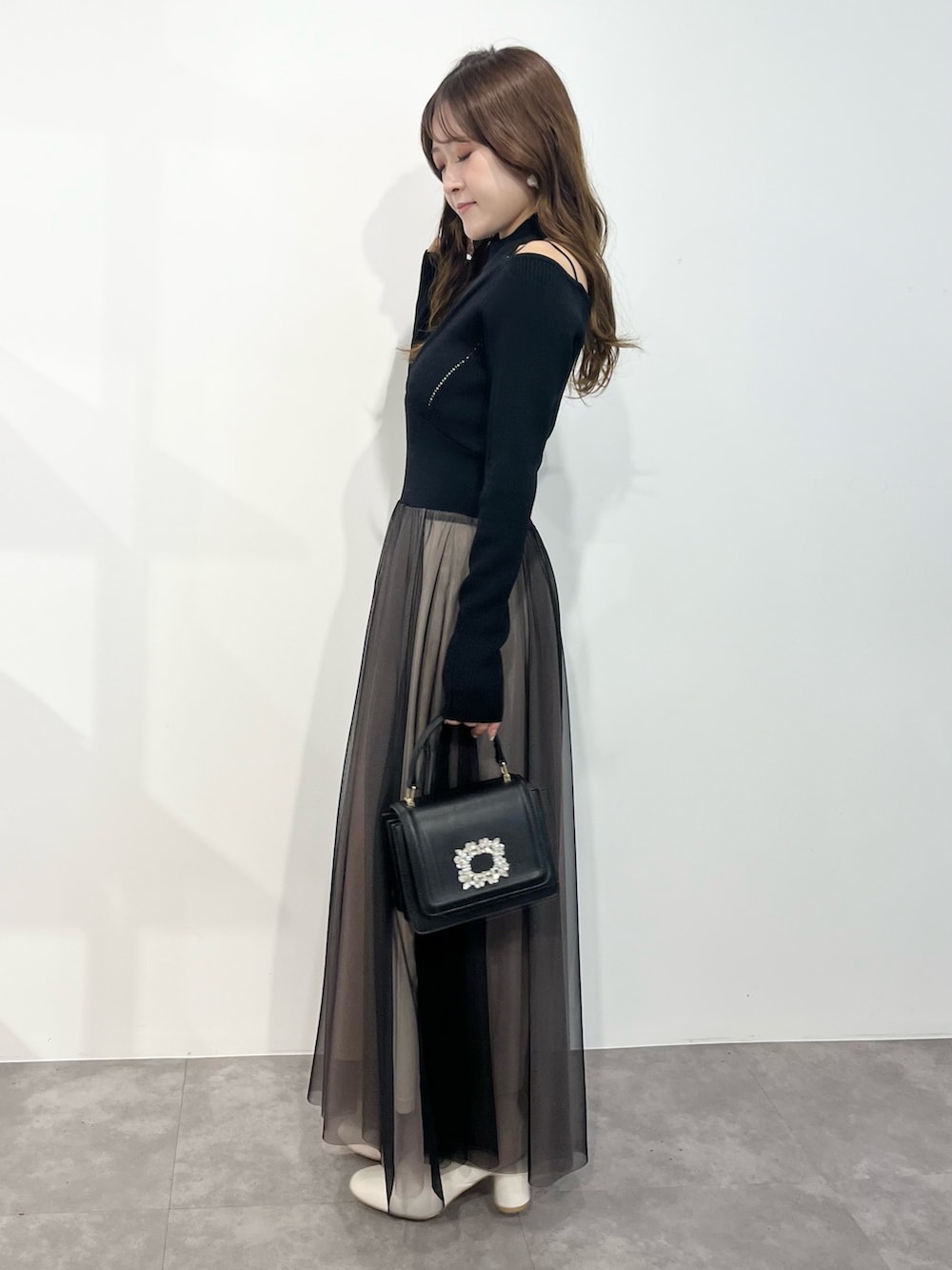 ブラック系のワンピース、ホワイト系のその他アウター、ブラック系のショルダーバッグを着用したレディースの冬コーディネートの4枚目の写真