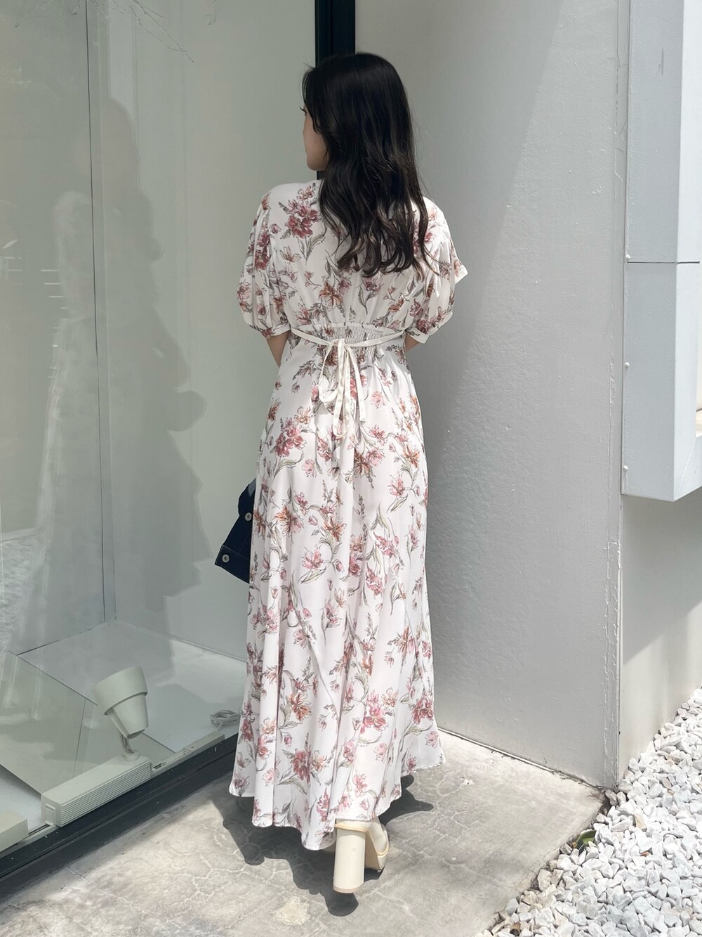 ホワイト系のワンピース、ブルー系のデニムジャケット、ホワイト系のブーツを着用したレディースの夏コーディネートの3枚目の写真