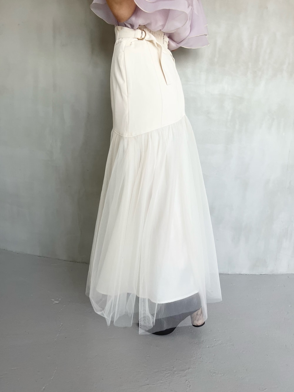 パープル系のシャツ/ブラウス、ホワイト系のスカート、ブラウン系のブーツを着用したレディースの春コーディネートの7枚目の写真