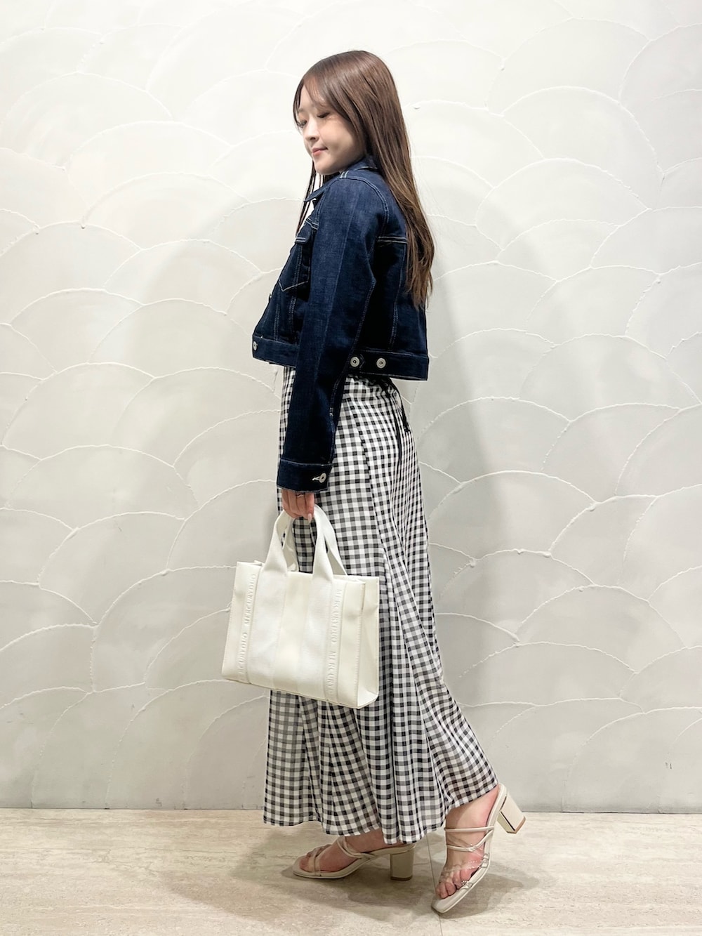 ブルー系のデニムジャケット、ピンク系のニット/セーター、その他のスカートを着用したレディースの春コーディネートの2枚目の写真