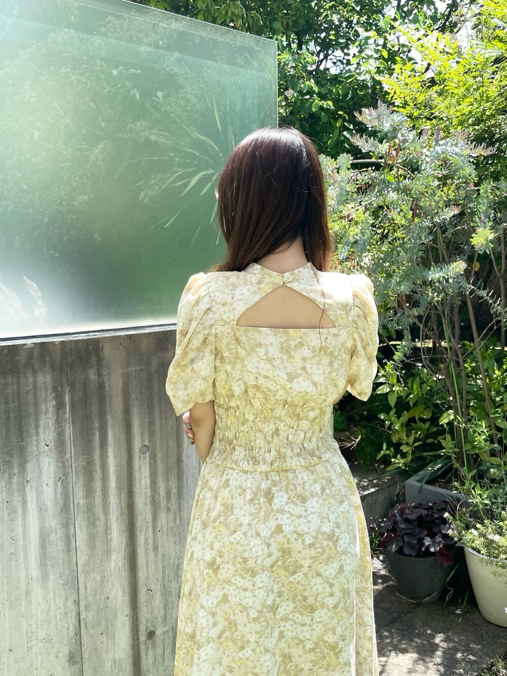 イエロー系のワンピース、ホワイト系のブーツを着用したレディースの夏コーディネートの4枚目の写真