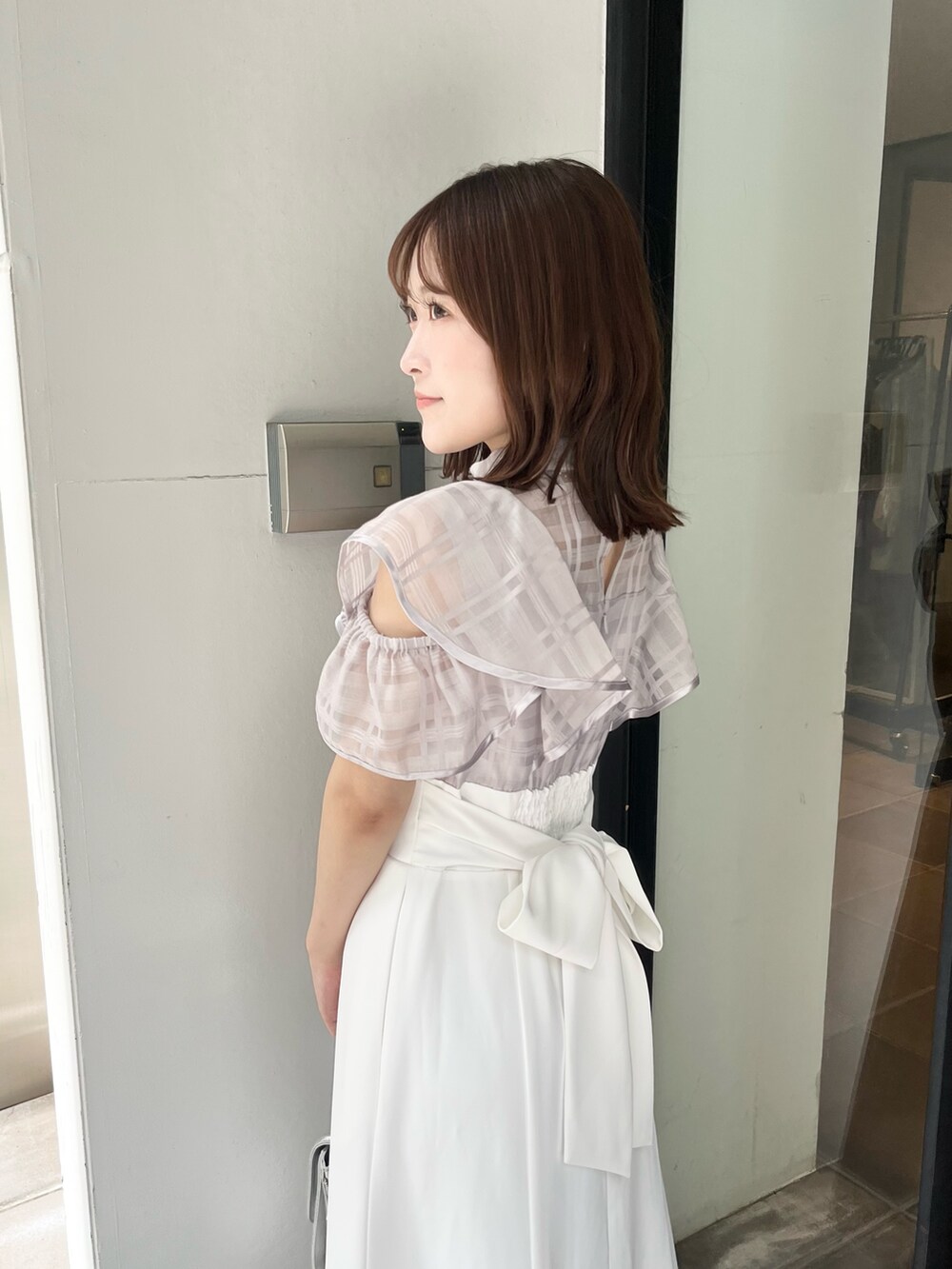 パープル系のワンピース、ブラウン系のサンダル、シルバー系のハンドバッグを着用したレディースの夏コーディネートの5枚目の写真