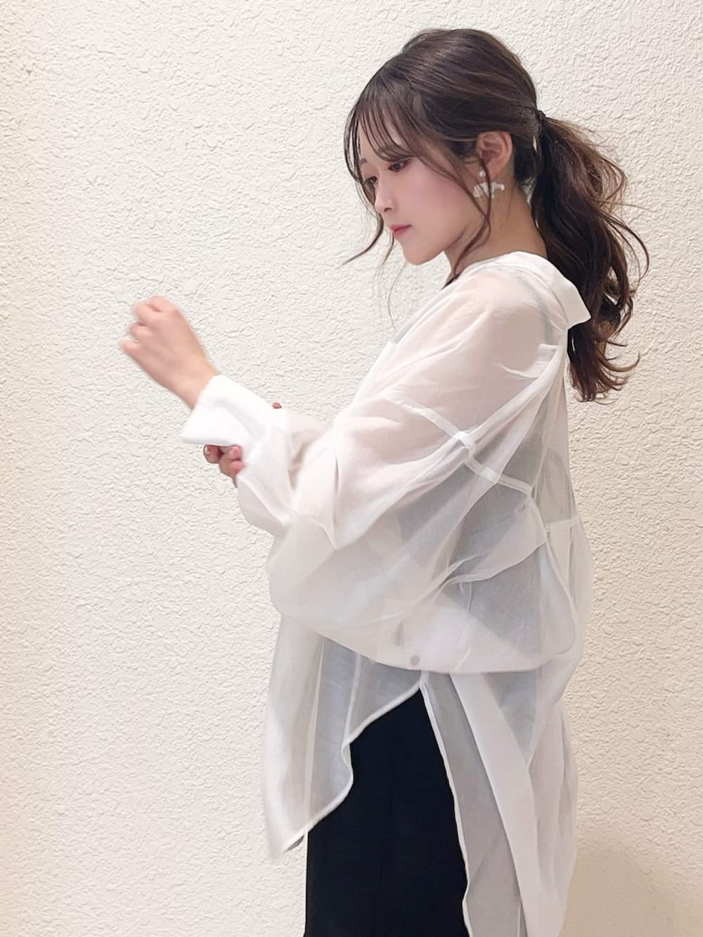 ブラック系のワンピース、ブラック系のサンダル、ホワイト系のシャツ/ブラウスを着用したレディースの春コーディネートの3枚目の写真