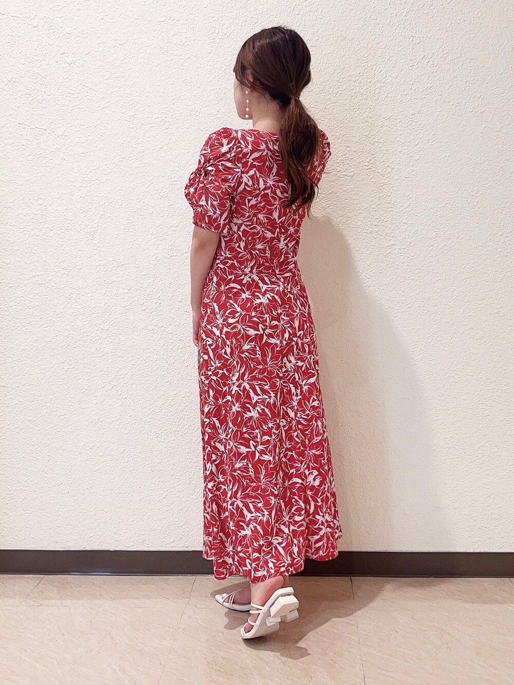 レッド系のワンピース、ホワイト系のサンダルを着用したレディースの春コーディネートの2枚目の写真