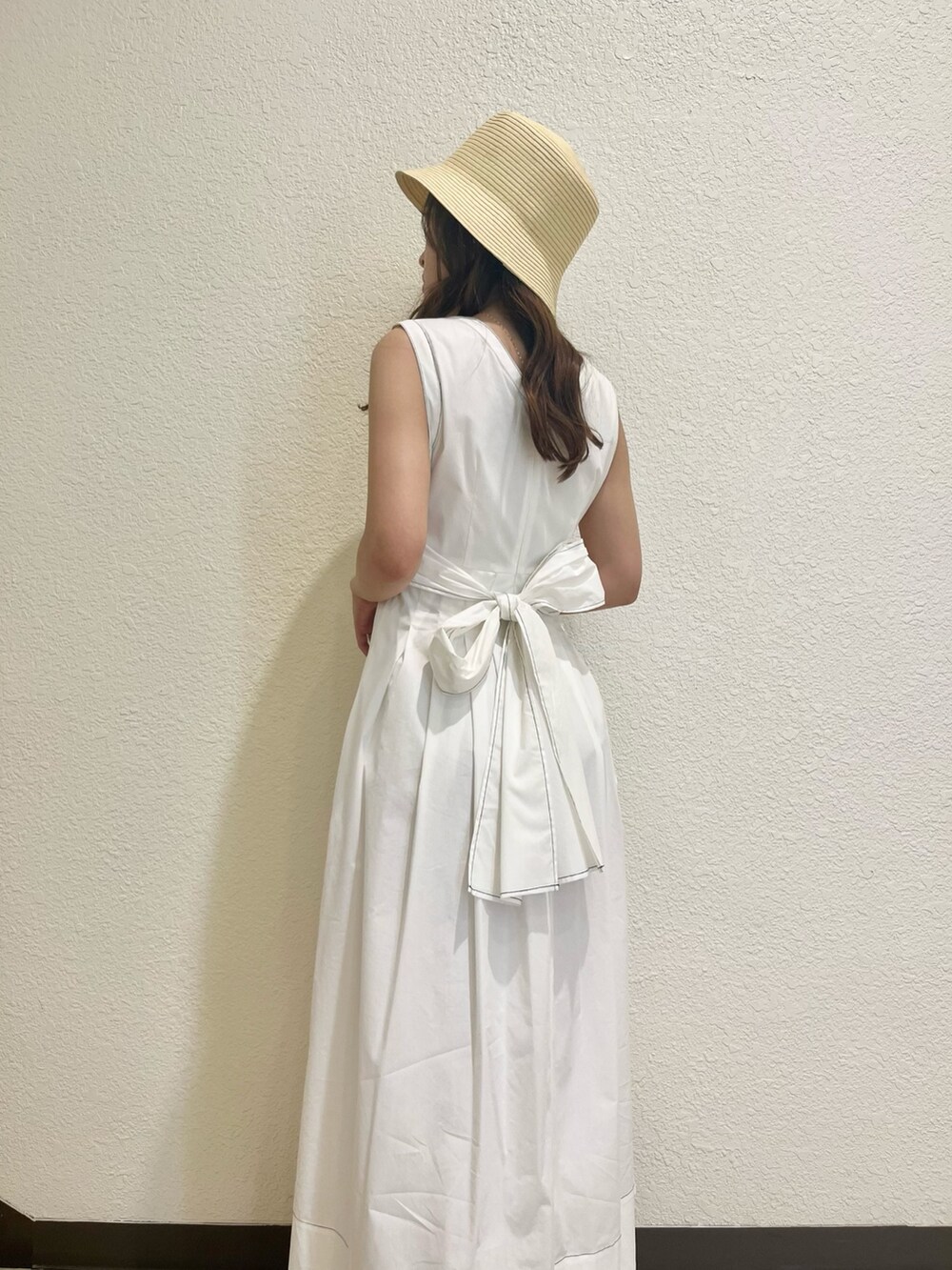 ホワイト系のワンピース、その他のサンダル、ベージュ系のハットを着用したレディースの春コーディネートの7枚目の写真