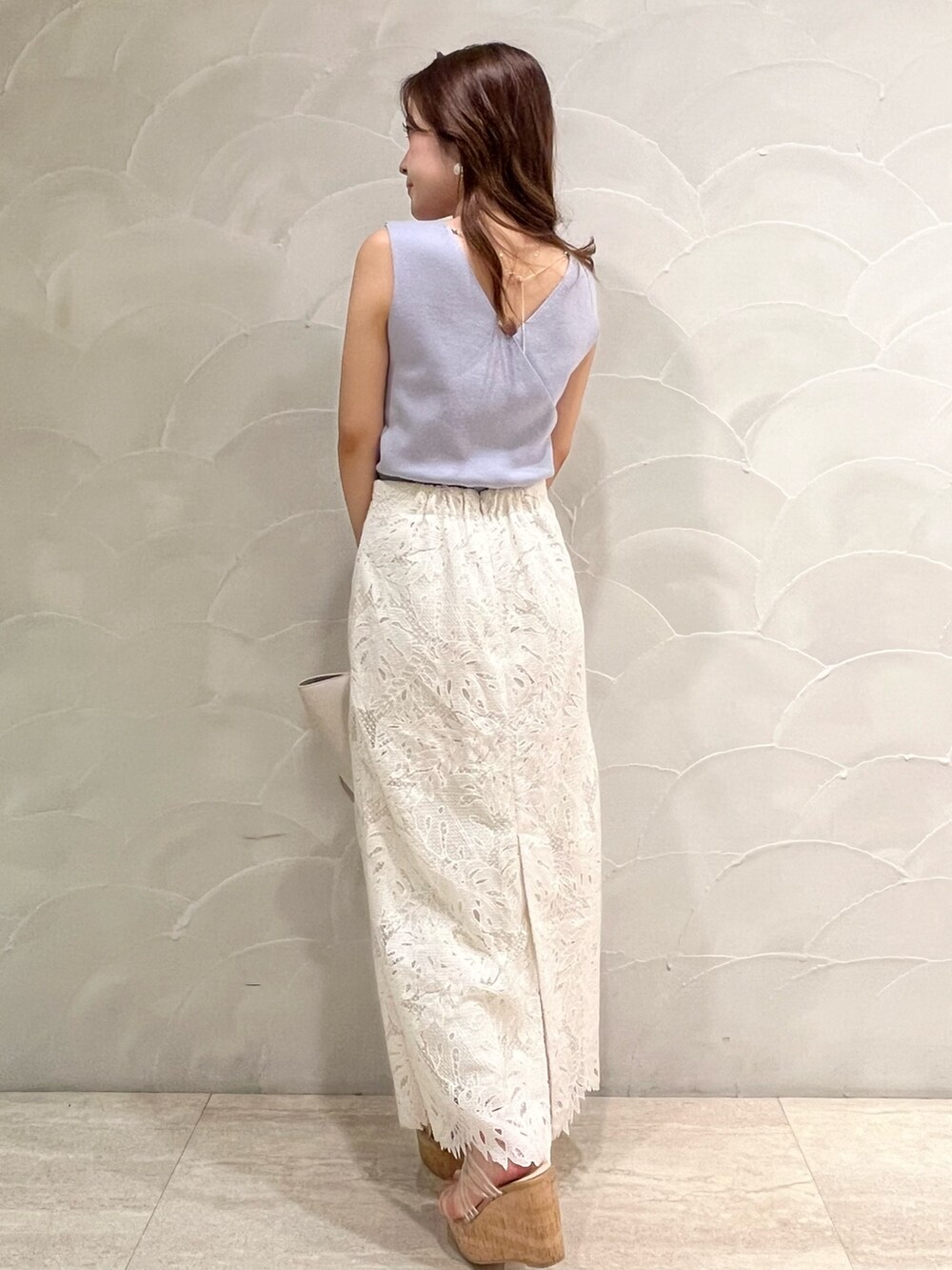 ホワイト系のスカート、その他のサンダル、ホワイト系のトートバッグを着用したレディースの夏コーディネートの3枚目の写真