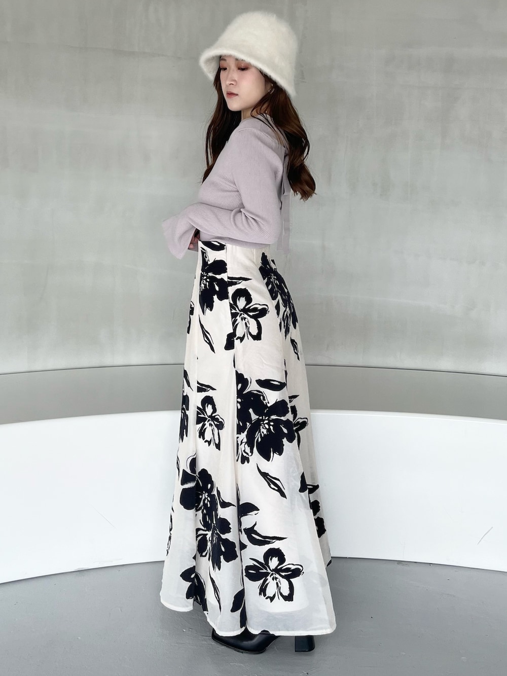 ホワイト系のスカート、パープル系のニット/セーター、ブラック系のブーツを着用したレディースの秋コーディネートの2枚目の写真