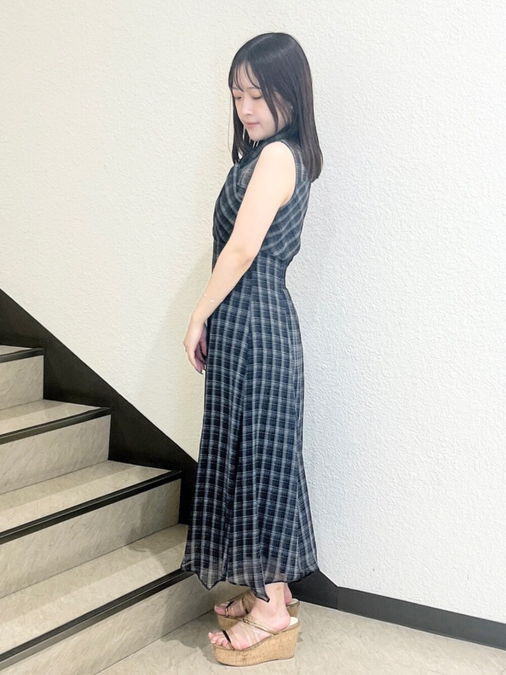 ブラウン系のサンダル、ブラック系のワンピースを着用したレディースの夏コーディネートの2枚目の写真