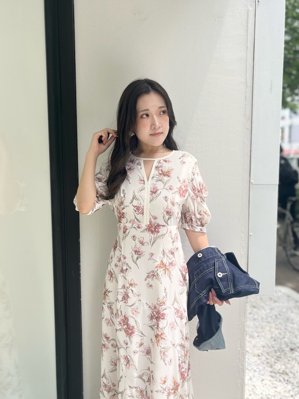 ホワイト系のワンピース、ブルー系のデニムジャケット、ホワイト系のブーツを着用したレディースの夏コーディネートの5枚目の写真