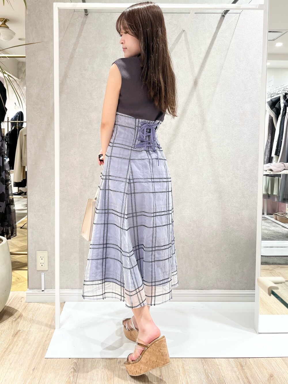 グレー系のワンピース、ベージュ系のショルダーバッグ、ブラウン系のサンダルを着用したレディースの春コーディネートの4枚目の写真