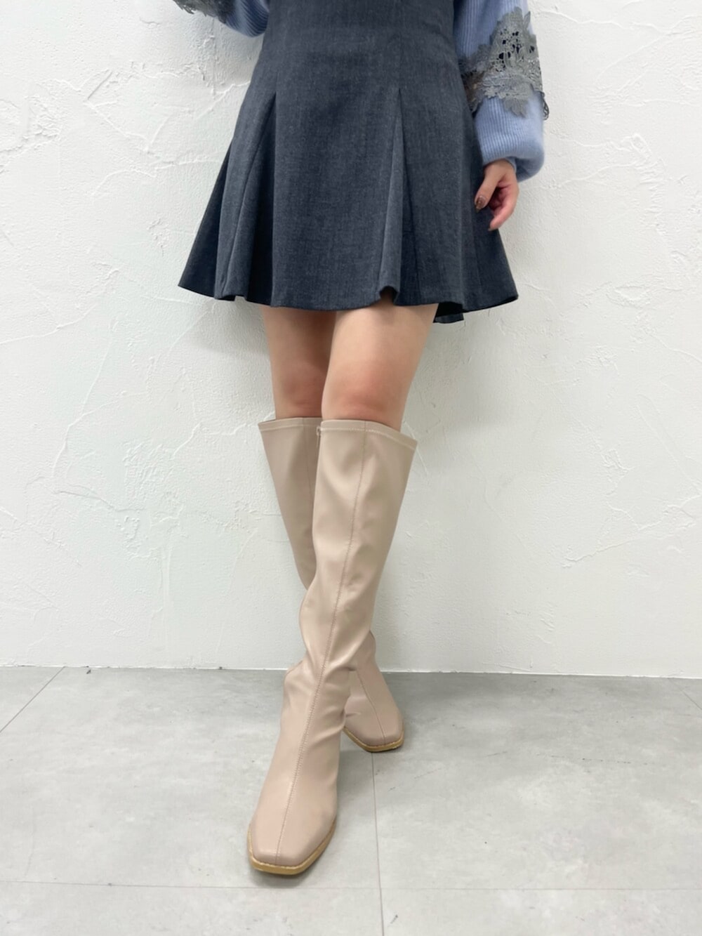 ベージュ系のブーツ、ブラック系のダウンジャケット/コート、ブルー系のニット/セーターを着用したレディースの秋コーディネートの5枚目の写真