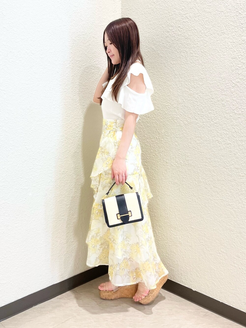 ホワイト系のニット/セーター、イエロー系のスカート、その他のサンダルを着用したレディースの春コーディネートの3枚目の写真
