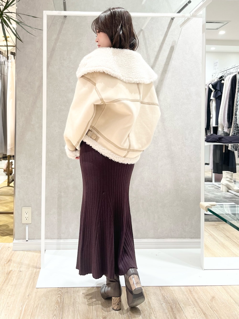 ベージュ系のムートンコート、ブラウン系のワンピース、ブラウン系のブーツを着用したレディースの冬コーディネートの3枚目の写真