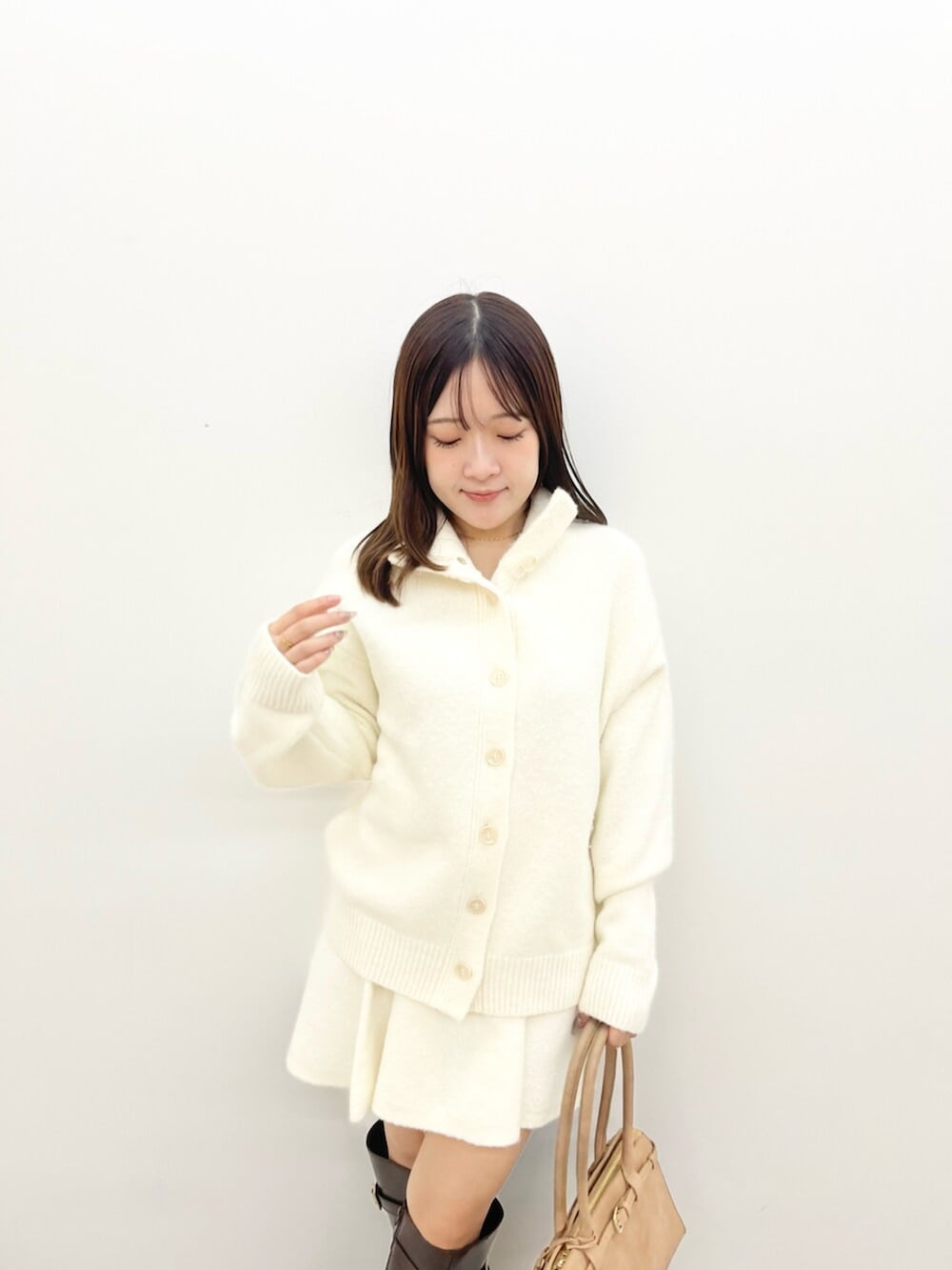 ホワイト系のワンピース、ブラウン系のブーツを着用したレディースの秋コーディネートの4枚目の写真