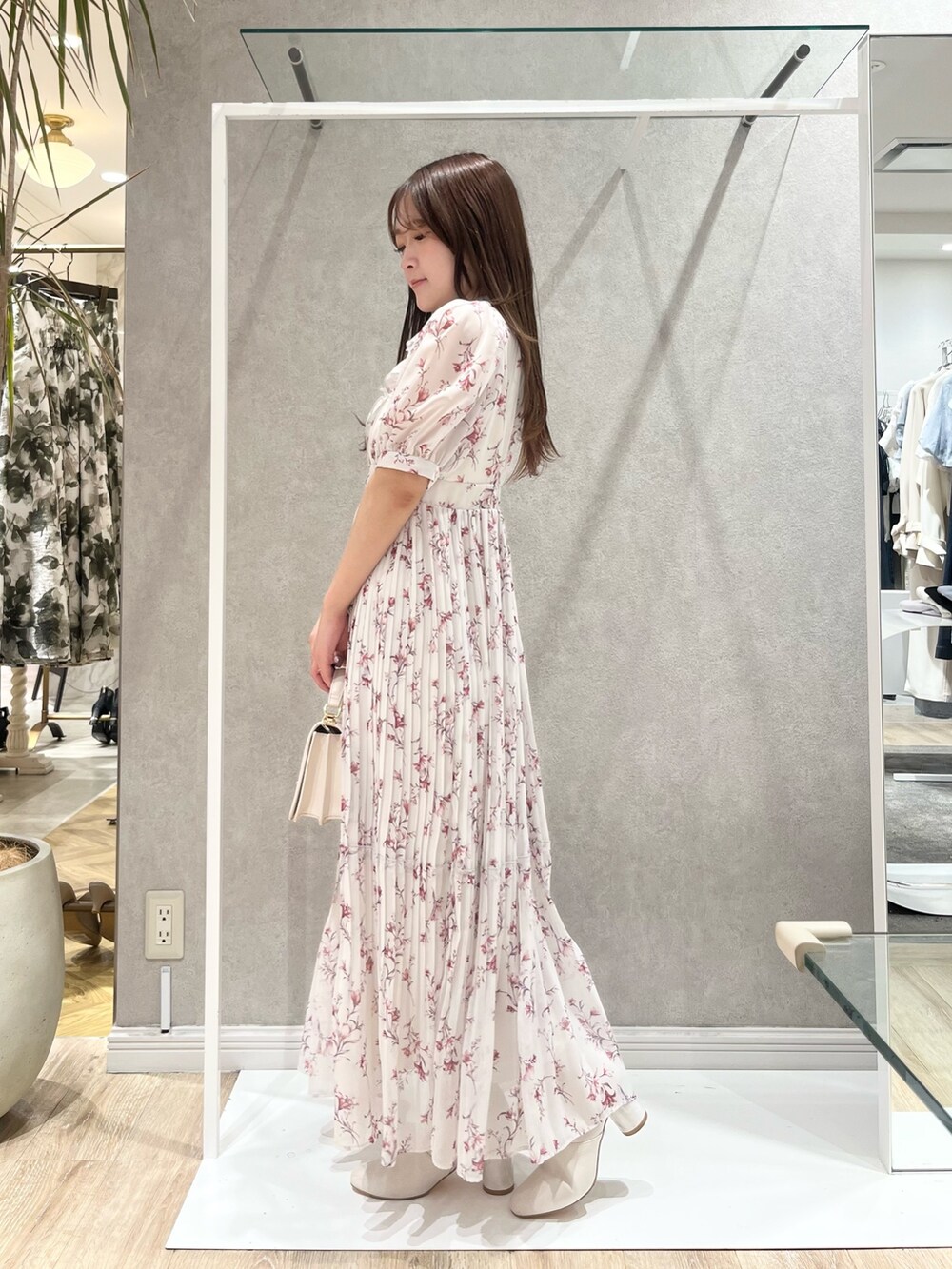 ホワイト系のトレンチコート、レッド系のワンピース、ホワイト系のハンドバッグを着用したレディースの春コーディネートの2枚目の写真