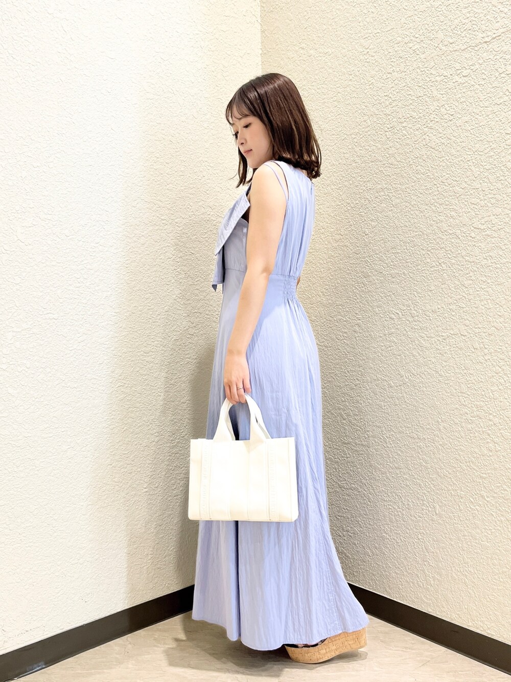 ブルー系のワンピース、ホワイト系のトートバッグ、ブラック系のサンダルを着用したレディースの夏コーディネートの2枚目の写真