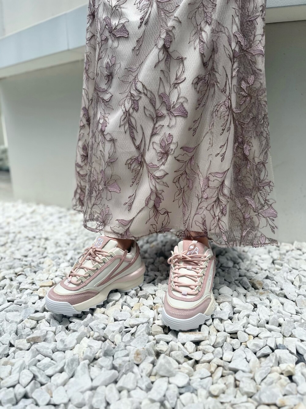 ピンク系のスカート、ピンク系のニット/セーター、ピンク系のスニーカーを着用したレディースの夏コーディネートの7枚目の写真