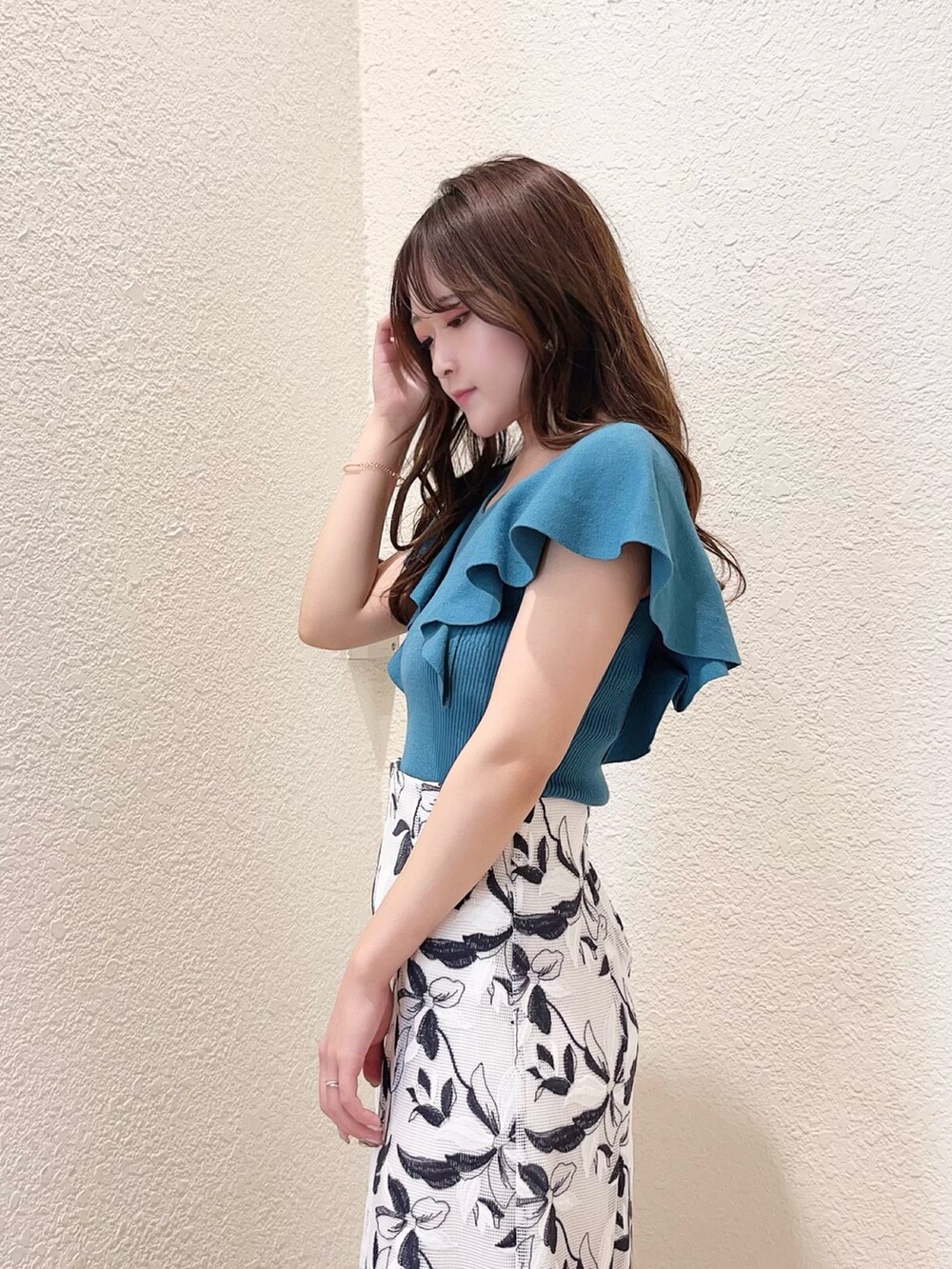 ホワイト系のスカート、グリーン系のニット/セーター、その他のサンダルを着用したレディースの春コーディネートの3枚目の写真