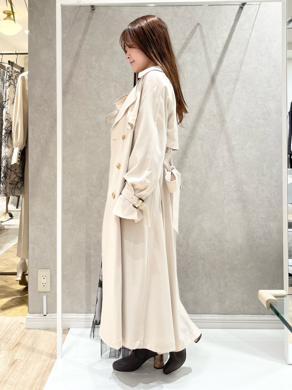 ホワイト系のトレンチコート、ブラック系のスカート、ブラック系のニット/セーターを着用したレディースの冬コーディネートの2枚目の写真