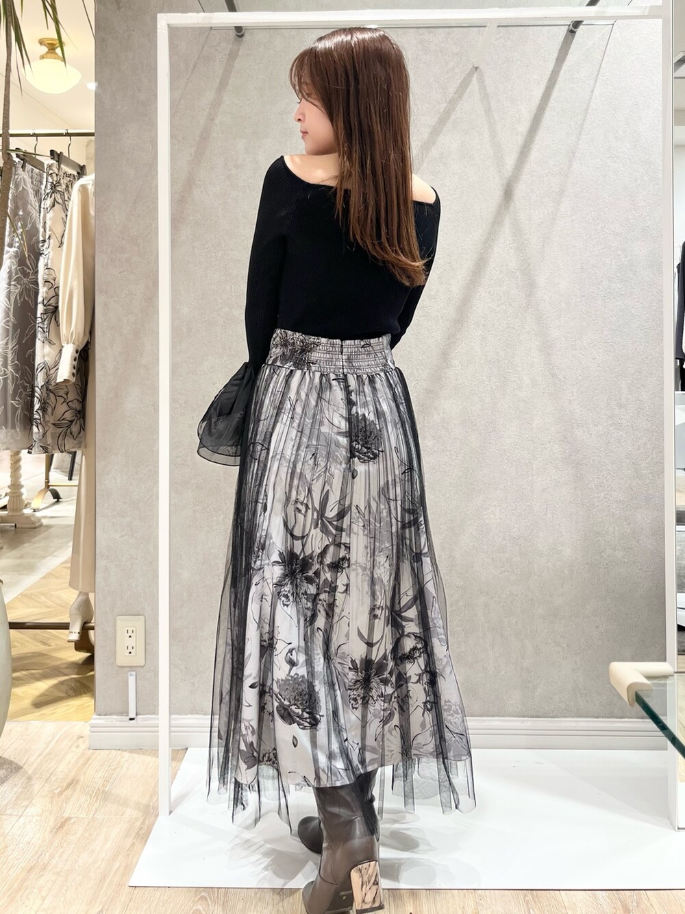 ホワイト系のトレンチコート、ブラック系のスカート、ブラック系のニット/セーターを着用したレディースの冬コーディネートの6枚目の写真