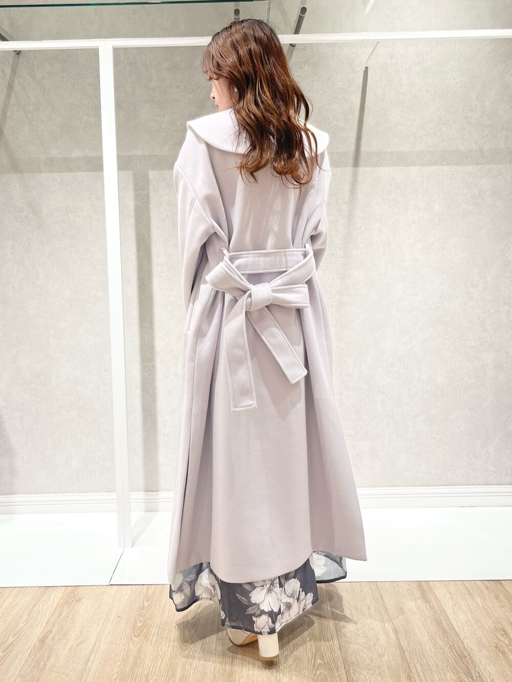 パープル系のチェスターコート、グレー系のワンピース、ホワイト系のショルダーバッグを着用したレディースの秋コーディネートの2枚目の写真