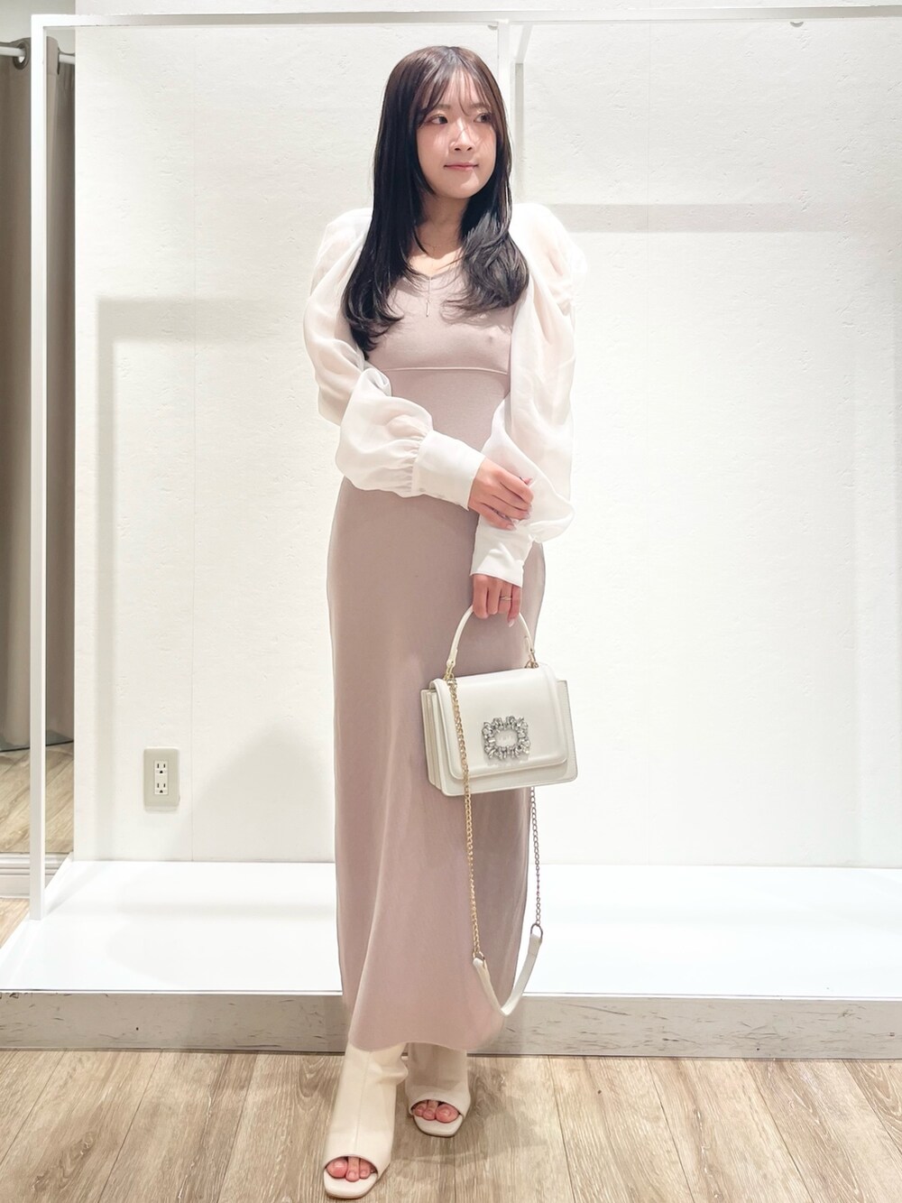 ホワイト系のトレンチコート、ベージュ系のワンピース、ホワイト系のショルダーバッグを着用したレディースの春コーディネートの4枚目の写真