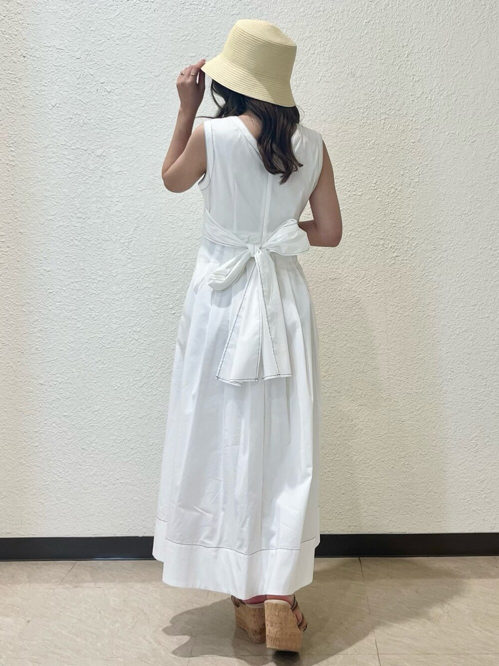 ホワイト系のワンピース、その他のサンダル、ベージュ系のハットを着用したレディースの春コーディネートの3枚目の写真