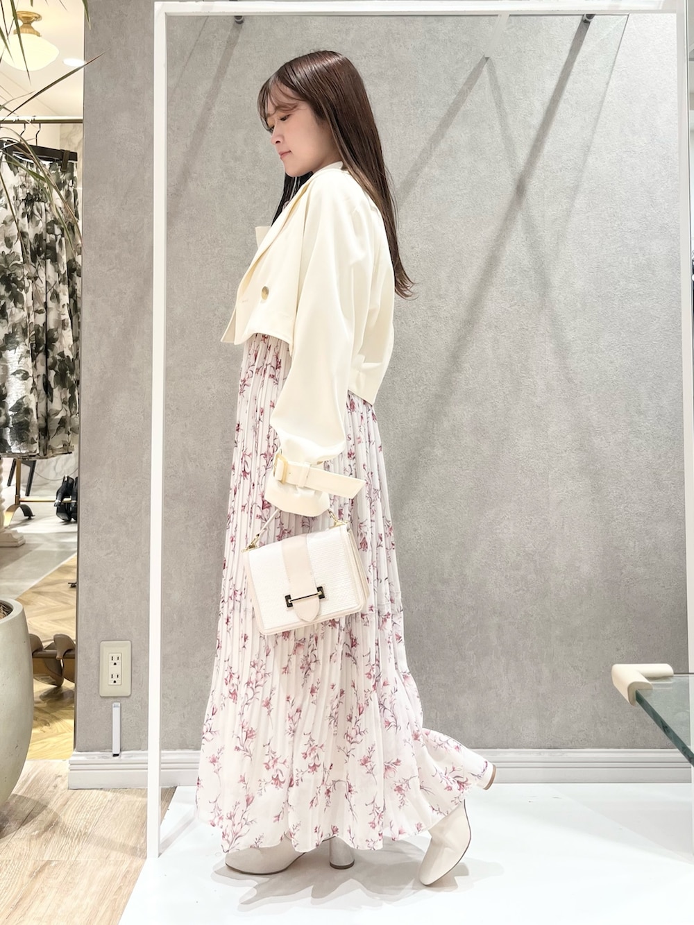 ホワイト系のトレンチコート、レッド系のワンピース、ホワイト系のハンドバッグを着用したレディースの春コーディネートの5枚目の写真