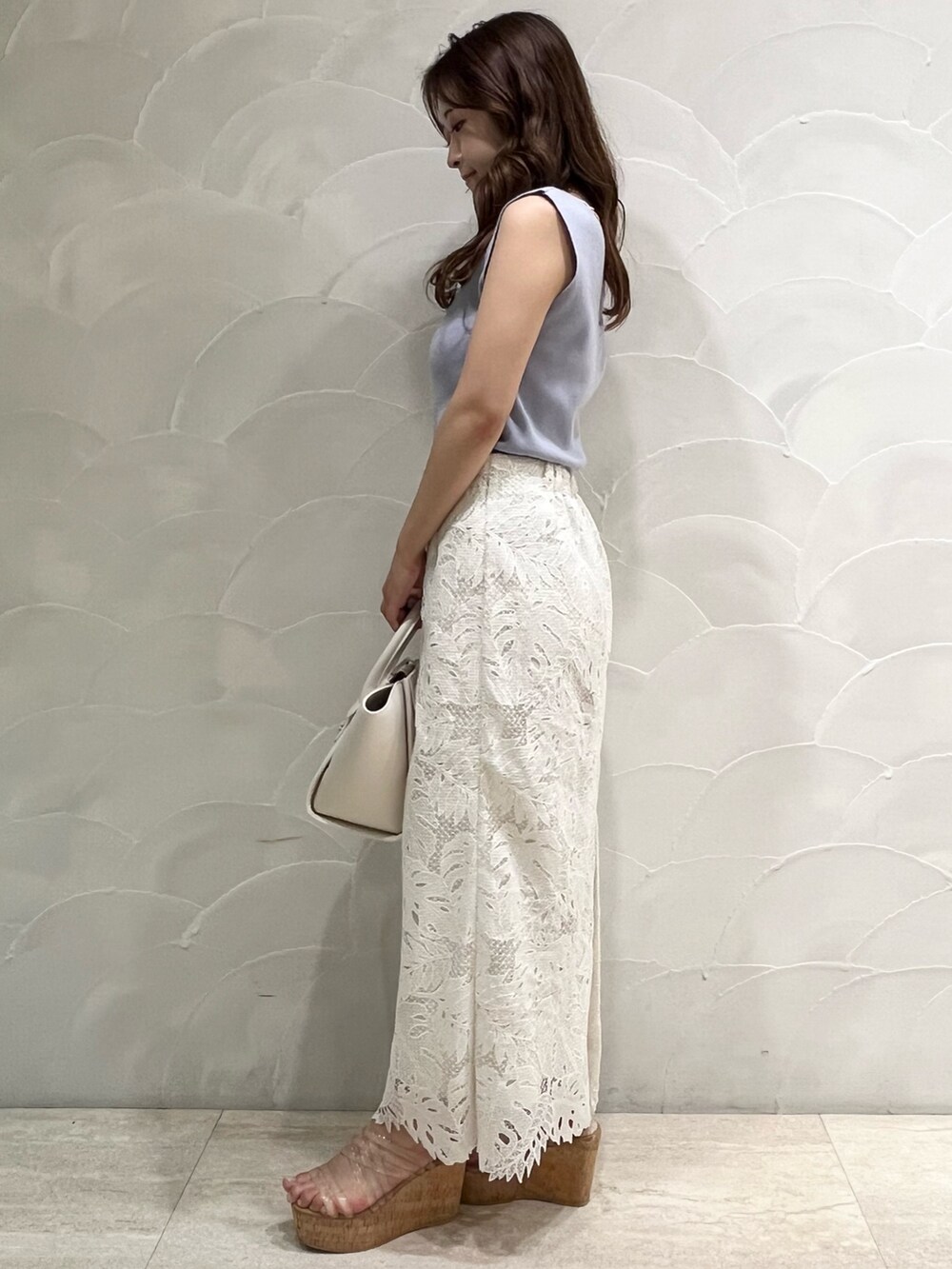 ホワイト系のスカート、その他のサンダル、ホワイト系のトートバッグを着用したレディースの夏コーディネートの2枚目の写真