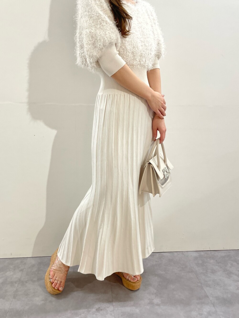 ホワイト系のワンピース、ベージュ系のショルダーバッグ、その他のサンダルを着用したレディースの春コーディネートの6枚目の写真