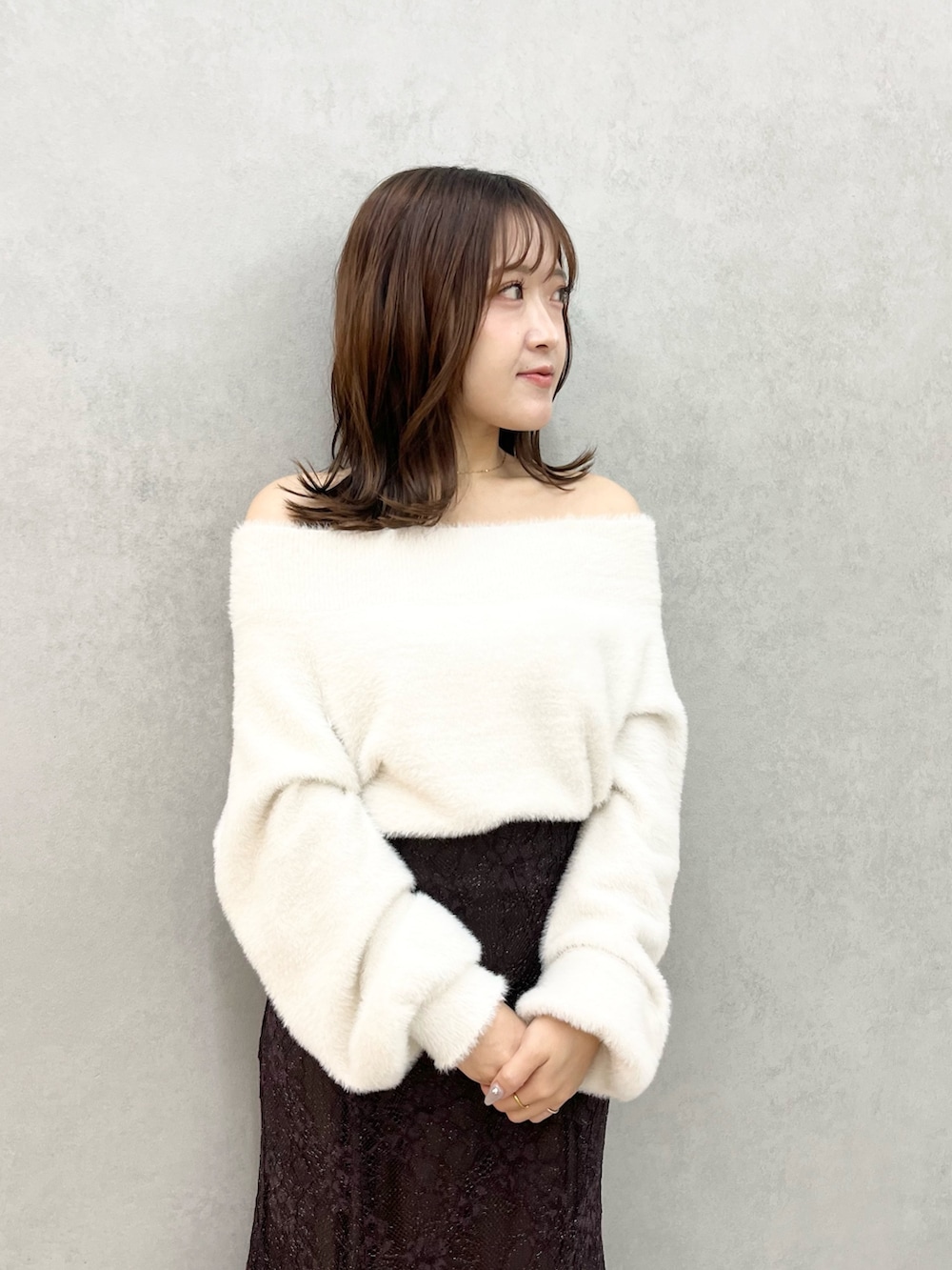 ホワイト系のニット/セーター、ブラウン系のスカート、ブラック系のブーツを着用したレディースの秋コーディネートの4枚目の写真