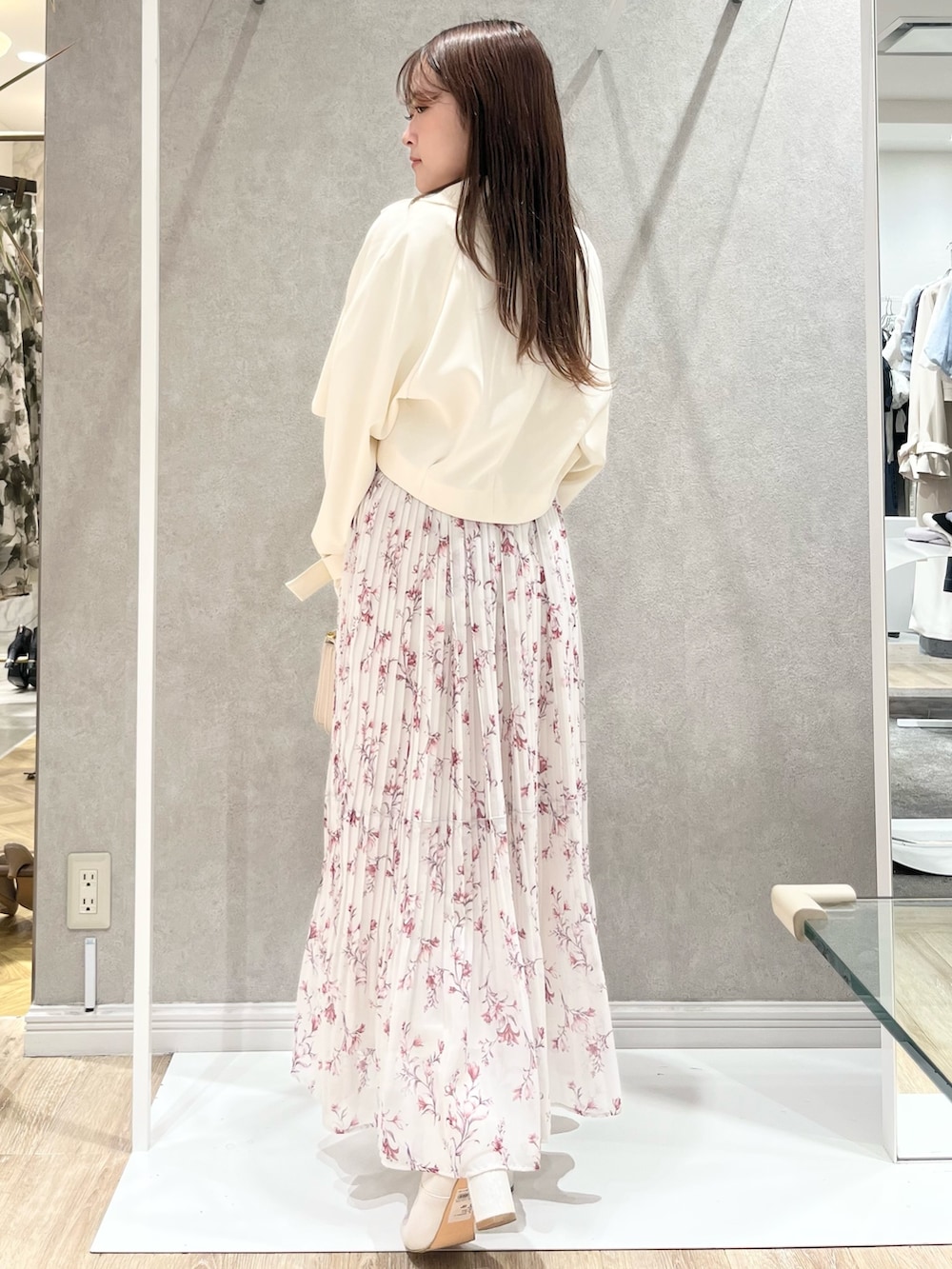 ホワイト系のトレンチコート、レッド系のワンピース、ホワイト系のハンドバッグを着用したレディースの春コーディネートの6枚目の写真