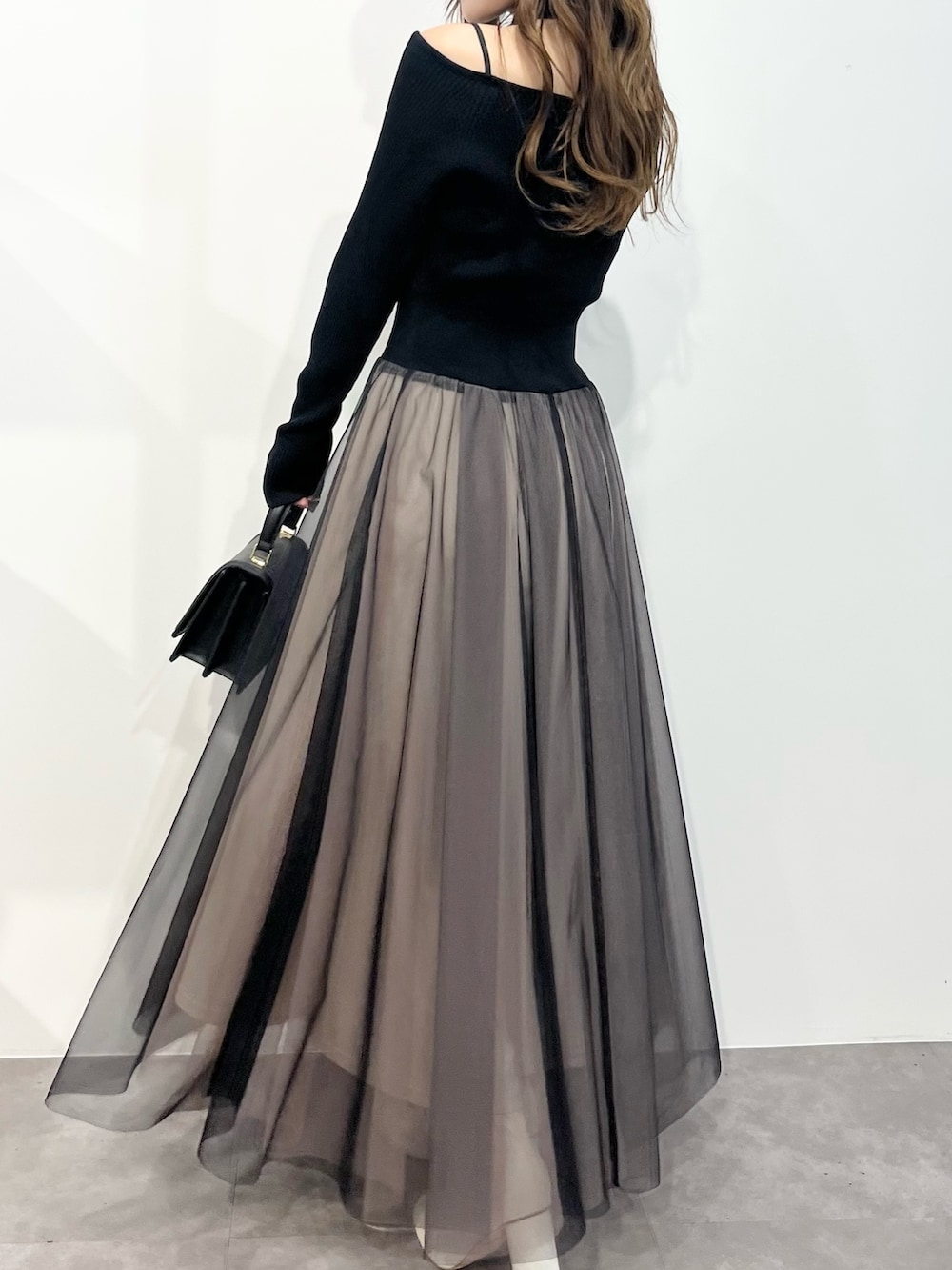 ブラック系のワンピース、ホワイト系のその他アウター、ブラック系のショルダーバッグを着用したレディースの冬コーディネートの6枚目の写真