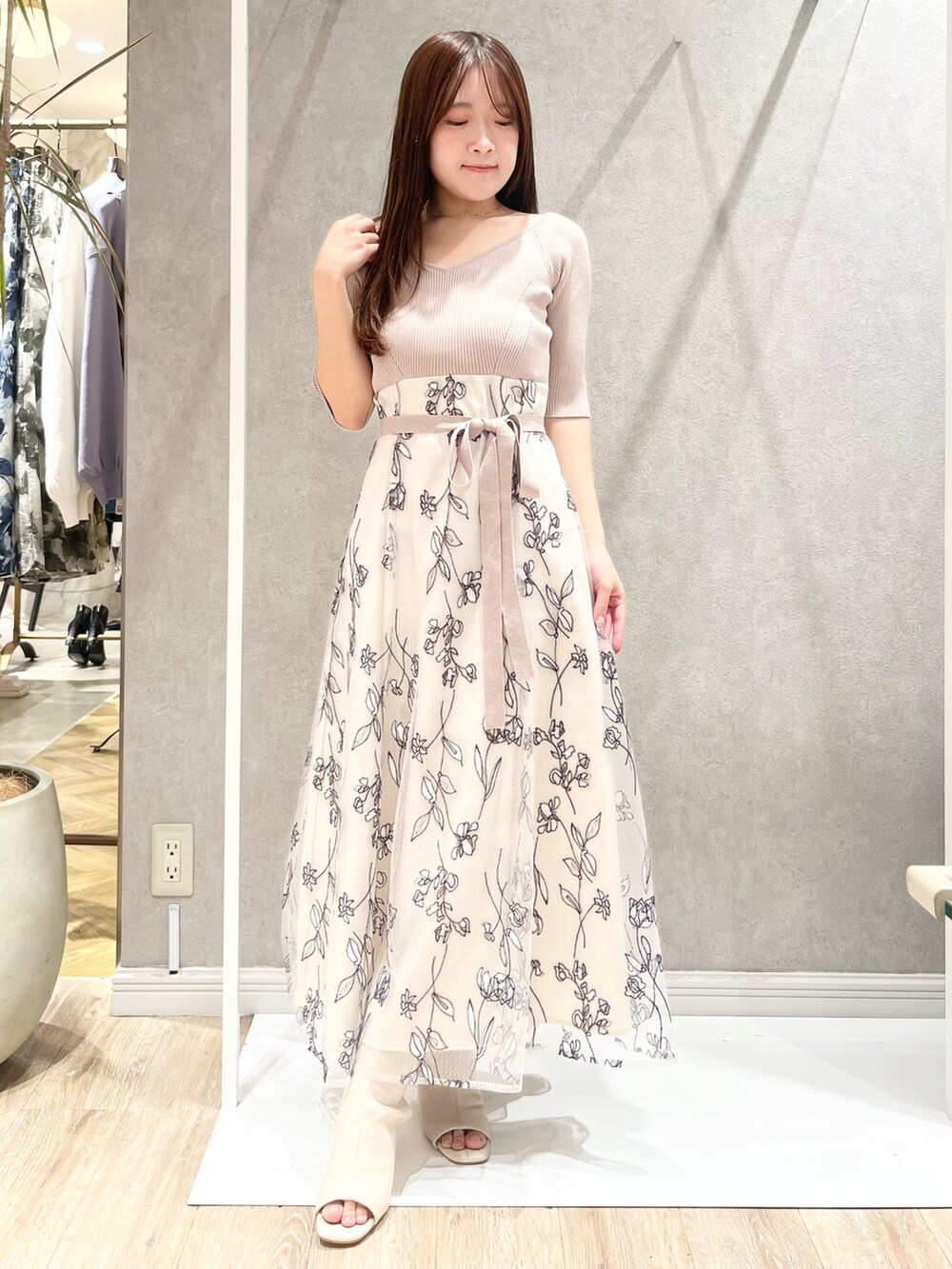 ベージュ系のワンピース、ホワイト系のライダースジャケット、ホワイト系のブーツを着用したレディースの春コーディネートの5枚目の写真