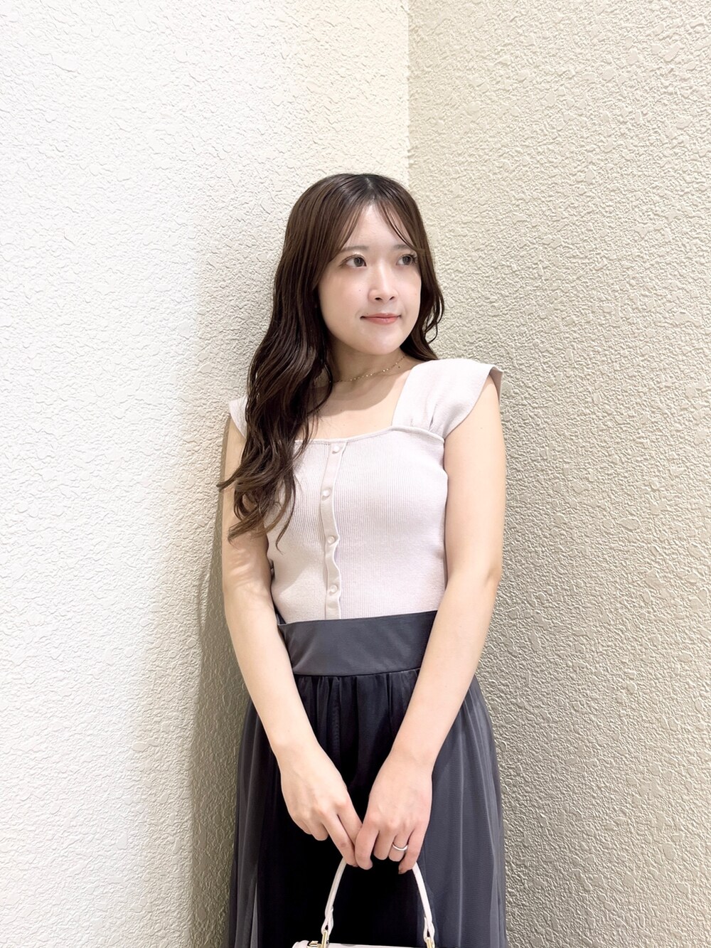 ピンク系のニット/セーター、ブラック系のスカート、ピンク系のショルダーバッグを着用したレディースの春コーディネートの6枚目の写真