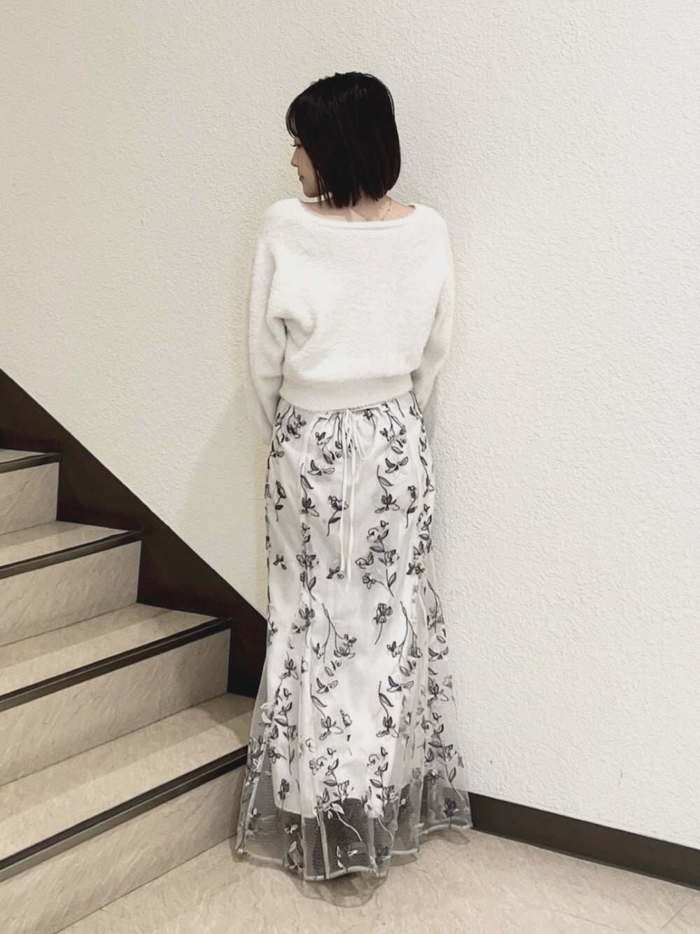 ホワイト系のスカート、ホワイト系のカーディガン/ボレロを着用したレディースの秋コーディネートの3枚目の写真