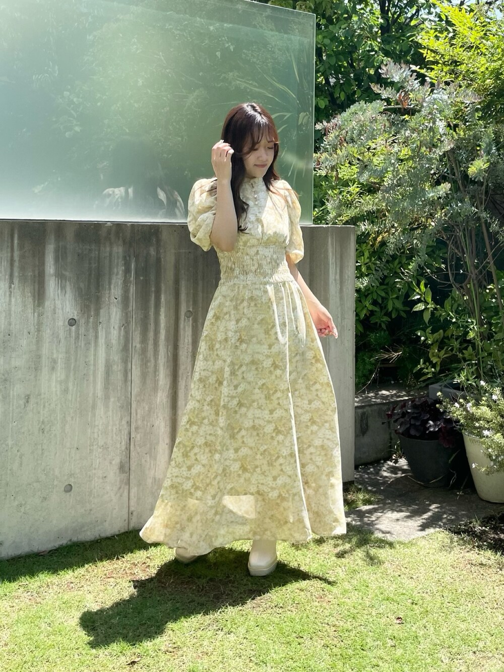 イエロー系のワンピース、ホワイト系のブーツを着用したレディースの夏コーディネートの7枚目の写真