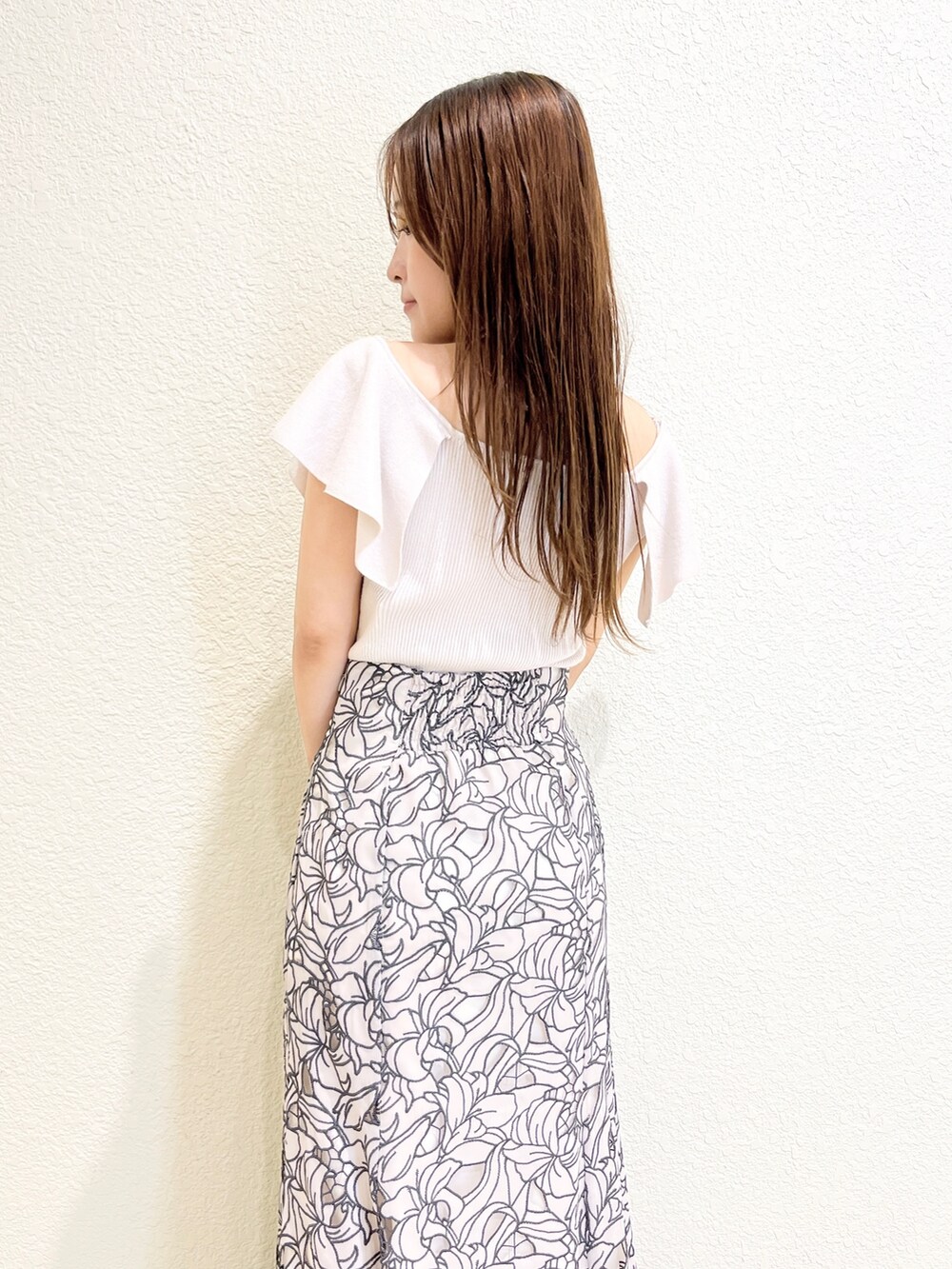 ピンク系のニット/セーター、ベージュ系のスカート、ブラック系のサンダルを着用したレディースの夏コーディネートの6枚目の写真