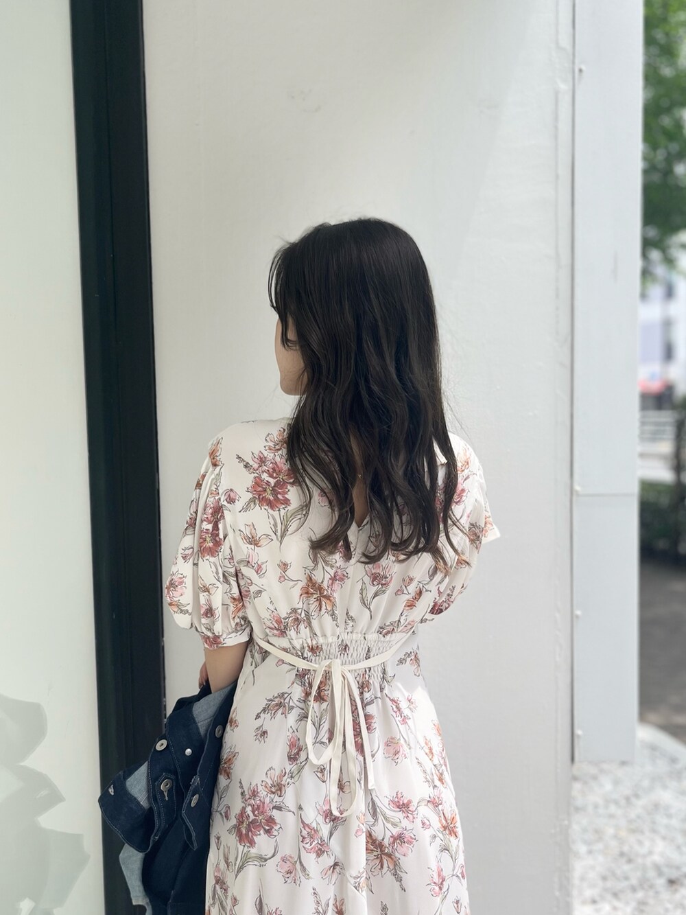 ホワイト系のワンピース、ブルー系のデニムジャケット、ホワイト系のブーツを着用したレディースの夏コーディネートの4枚目の写真