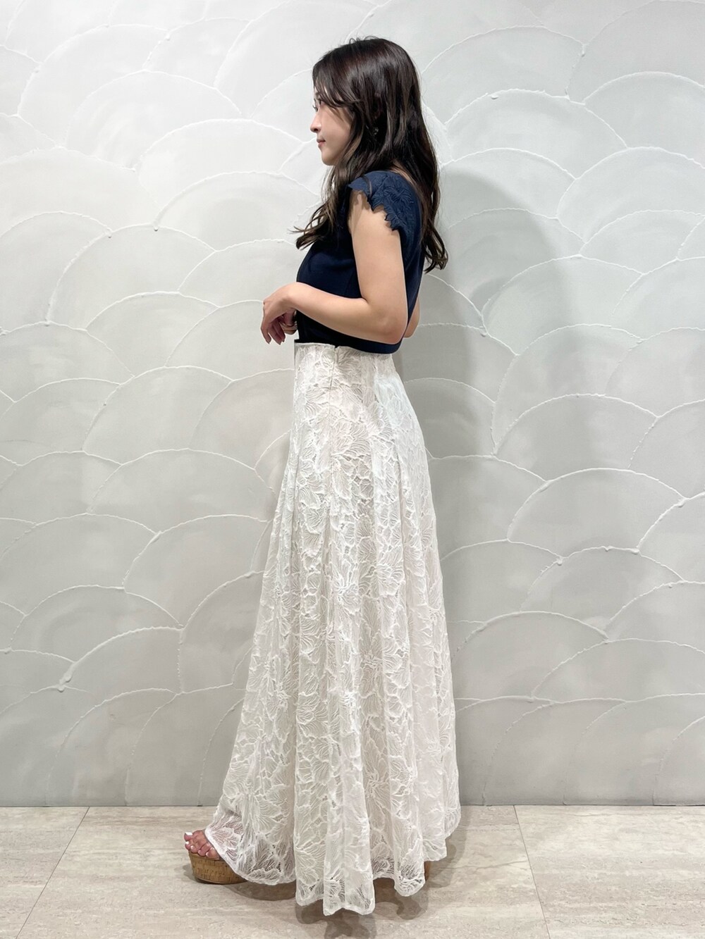 ホワイト系のスカート、ブルー系のニット/セーター、その他のサンダルを着用したレディースの夏コーディネートの2枚目の写真