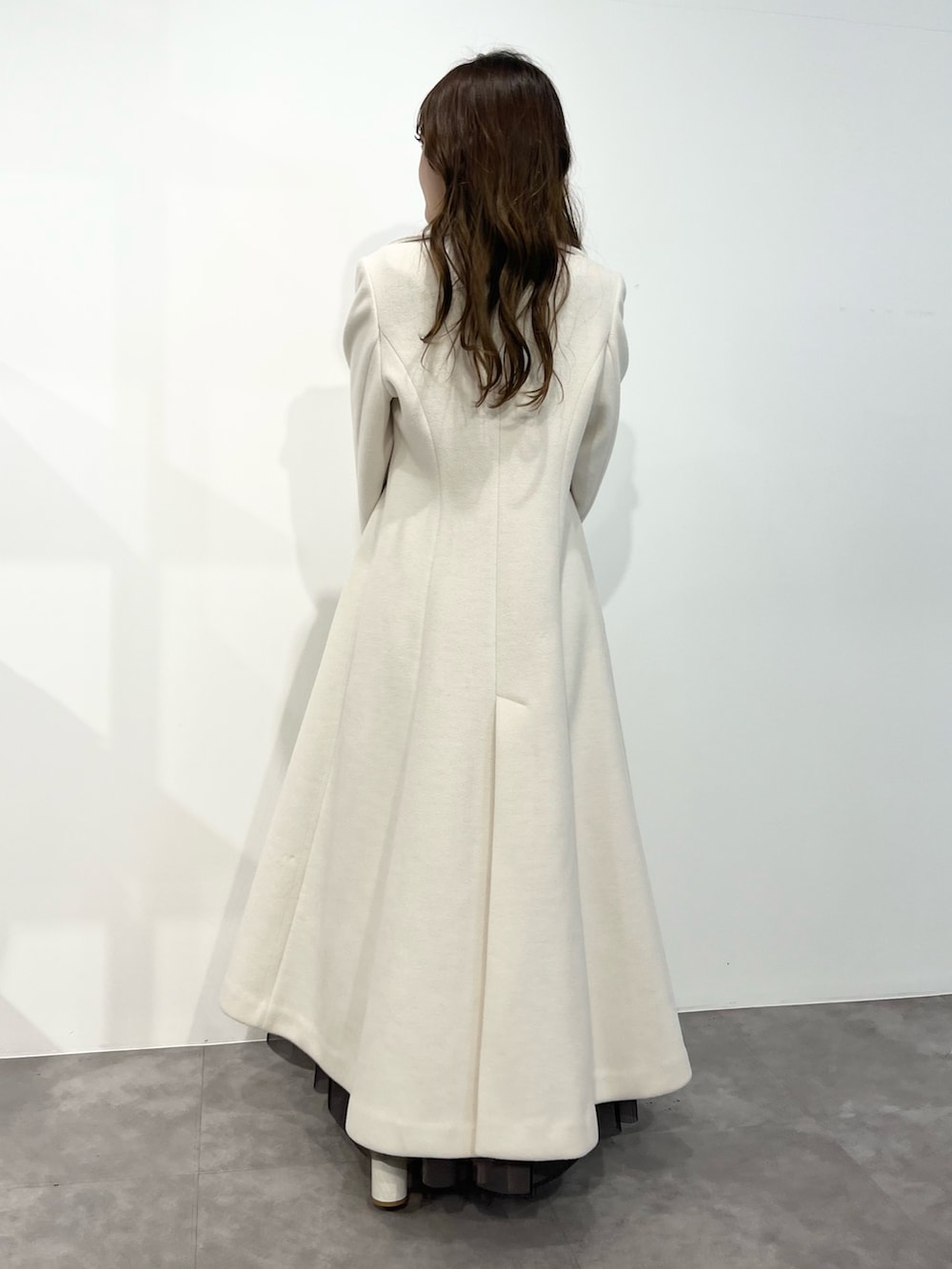 ブラック系のワンピース、ホワイト系のその他アウター、ブラック系のショルダーバッグを着用したレディースの冬コーディネートの2枚目の写真